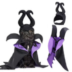 Dog wearing a Maleficent costume with black horns and purple accents on a white background