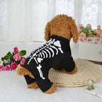 Dog wearing a black skeleton costume with a white curtain and flowers in the background