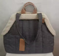 Gray pet carrier with brown leather accents on a white background