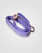 Purple dog leash with rose gold clip on a light gray background