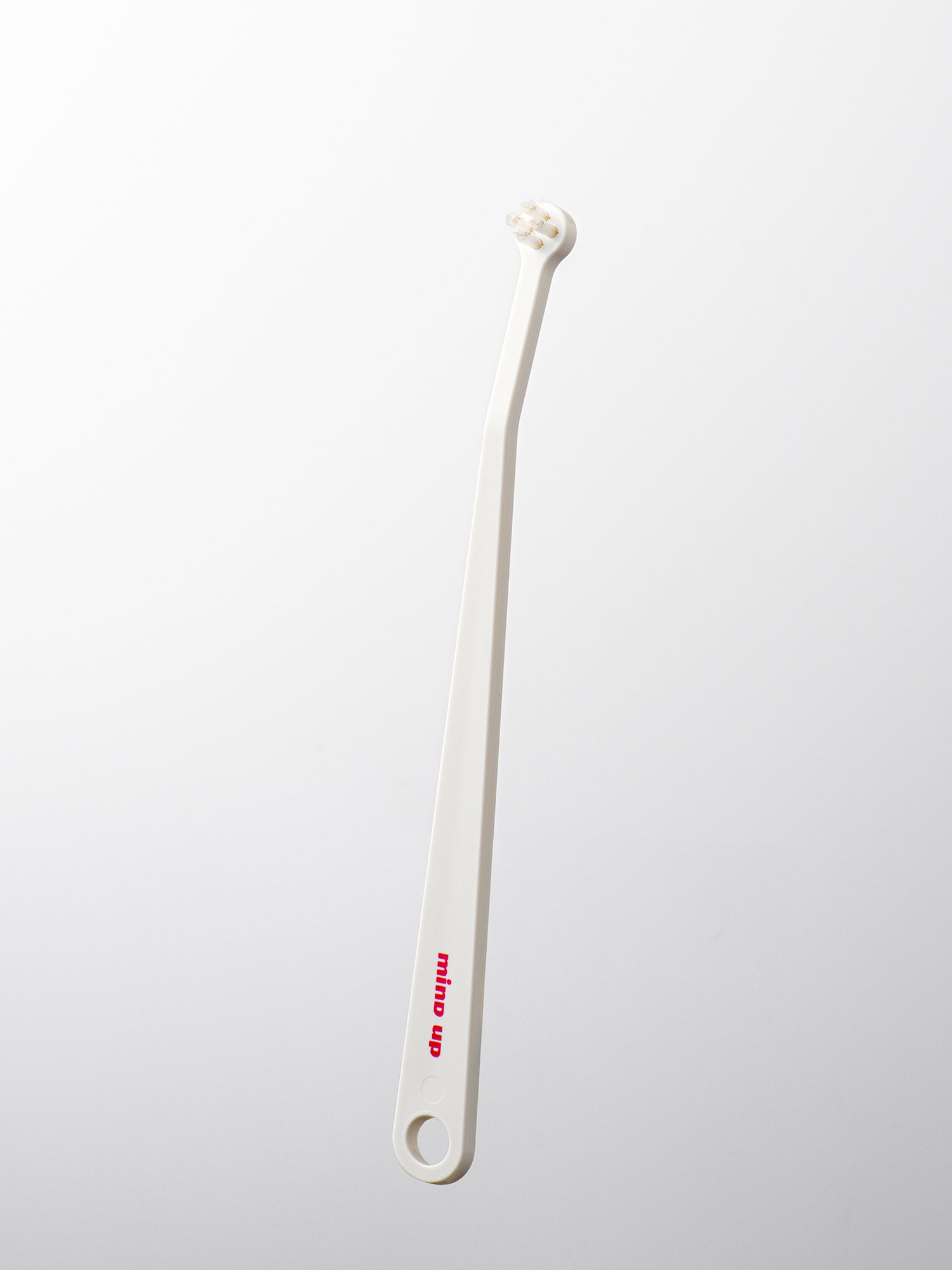 White cat toothbrush on a light gray background
