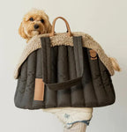 Dog inside a grey pet carrier with a beige interior on a plain background