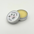 Puppy Paw Salve in a metal tin on a light gray background