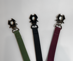 Three dog leash in green, black, and purple with metal clasps on a white background.