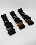Three black dog collars with different metal buckles on a white background