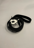 Black dog leash with metal clip on a light gray background