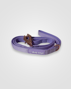 Purple dog leash with brown clip on a white background