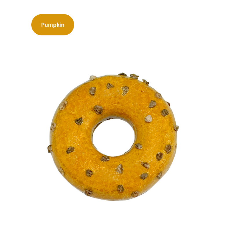 Yellow donut-shaped cat toy with studs on a white background