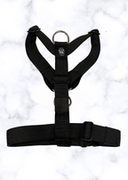 Black dog harness on a light gray background