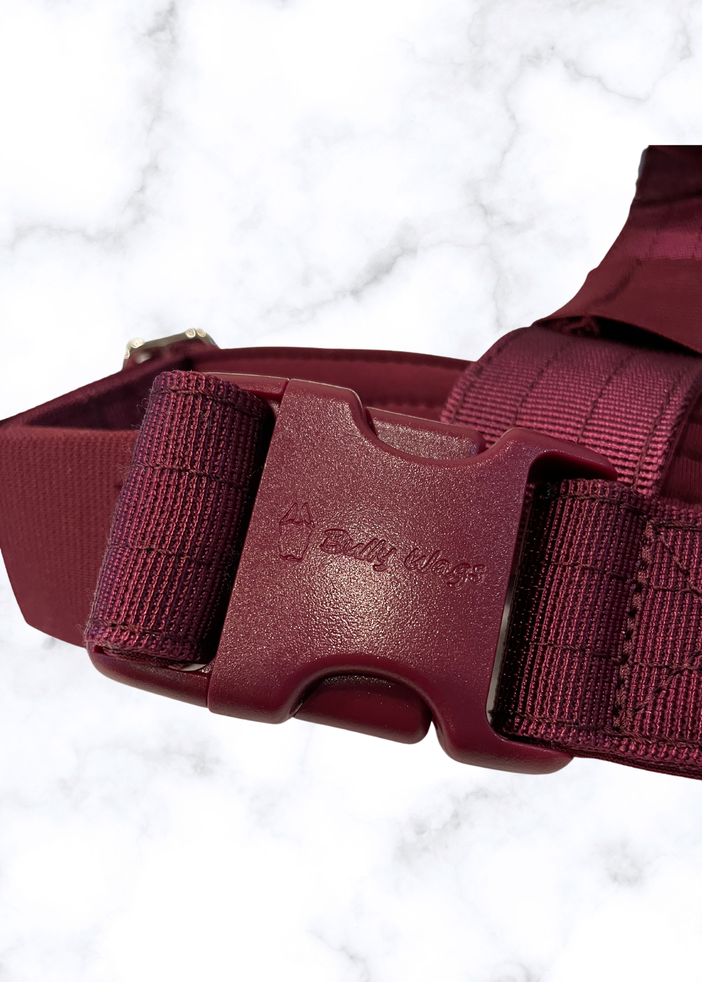 Cherry wine harness with a visible brand logo on a light gray background