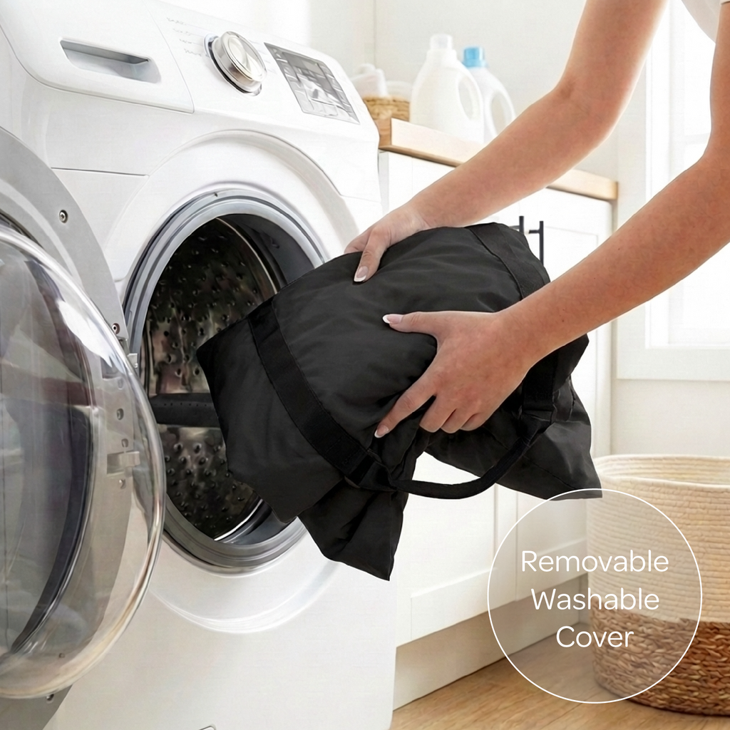 Person placing a black pet car seat cover into a washing machine with a focus on the removable washable cover feature.