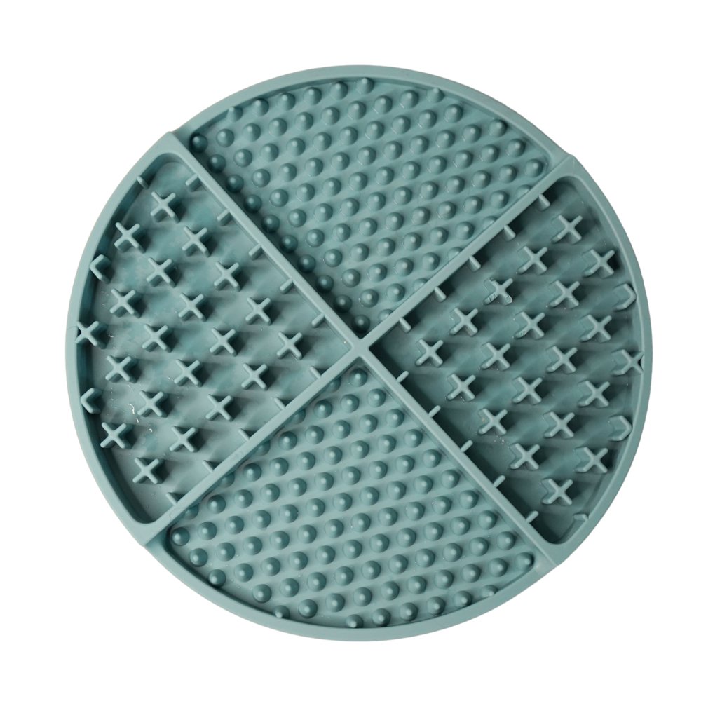 Round green silicone lick mat with textured surface on a white background