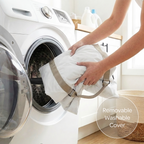 Person placing a white pet car seat cover with a beige strap into a washing machine, with a focus on the removable washable cover feature.