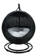 Black wicker hanging chair with white cushion on a white background