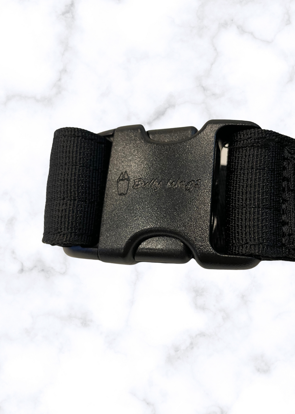 Black belt with a buckle on a white marble background