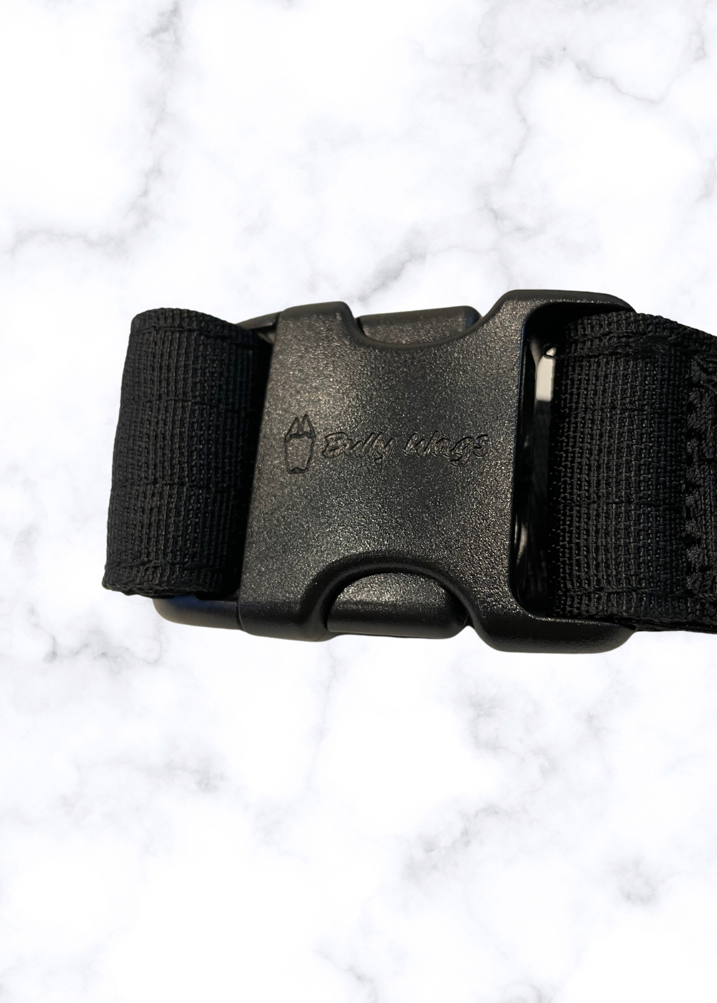Black belt with a buckle on a white marble background