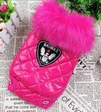 Pink dog coat with a large fur pom-pom on a newspaper background