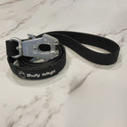 Black dog leash with metal clip on a marble surface