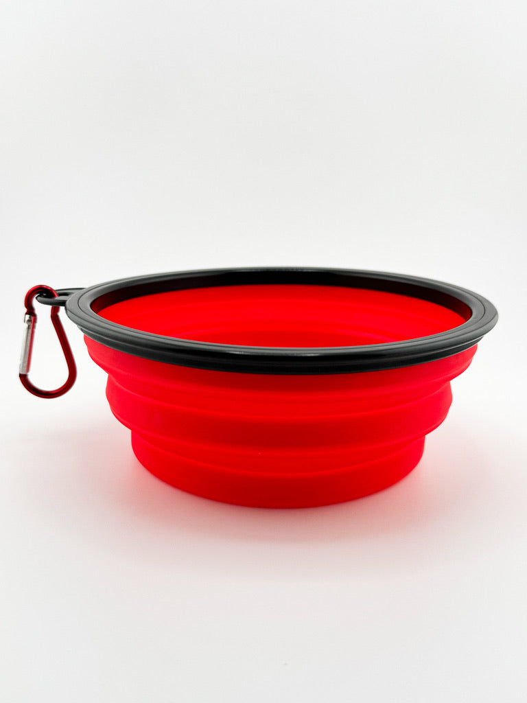 Red silicone folding bowl with black rim on a white background