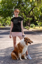 Woman wearing a black t-shirt with 'Best Dog Mom Ever' text, standing with a dog on a street.