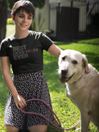 Woman wearing a 'BEST DOG MOM EVER' shirt with a dog on a leash in a grassy area.