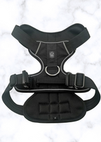 Black dog harness on a light gray background