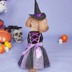 Dog in a Halloween witch costume with pumpkins and skulls on a purple background