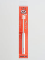 White dog toothbrush with orange packaging featuring a cartoon character on a white background