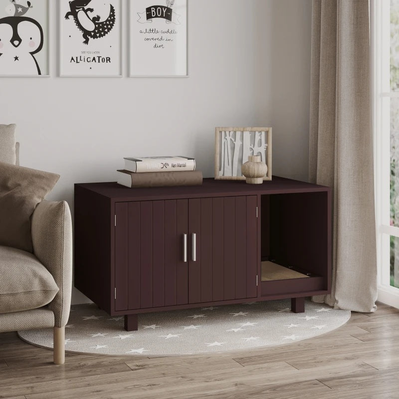 Dark brown cat litter cabinet in a living room with a couch and framed pictures on the wall.