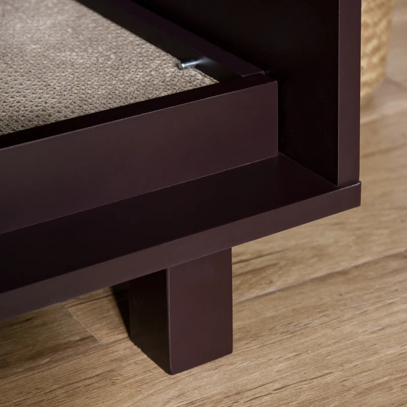 Close-up of a wooden cat litter cabinet with a scratch pad on a wooden floor.