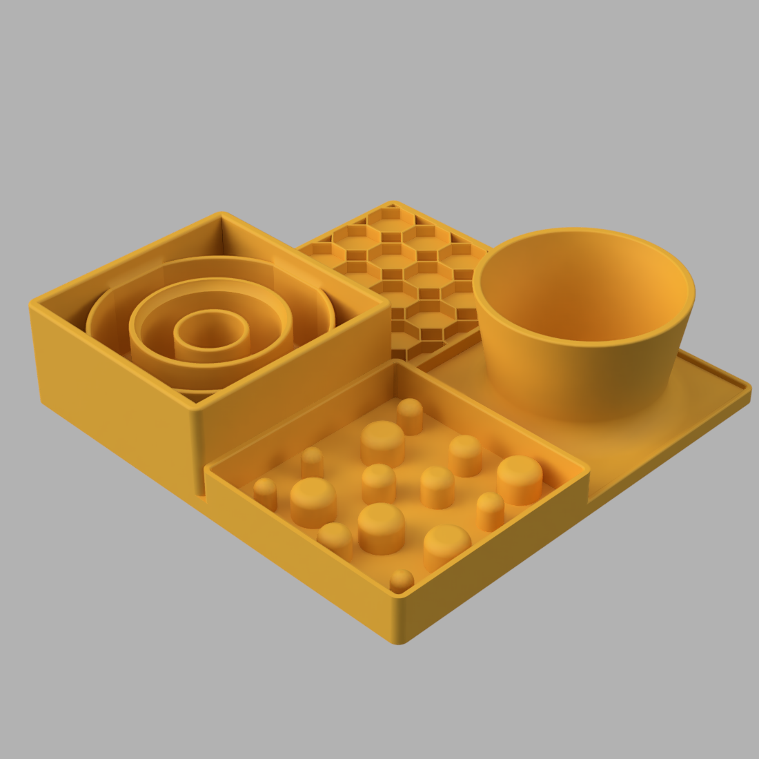 A yellow slow feeder set on a light gray background, featuring a bowl, a tray with small raised spheres, a spiral insert, and a hexagonal grid mat.