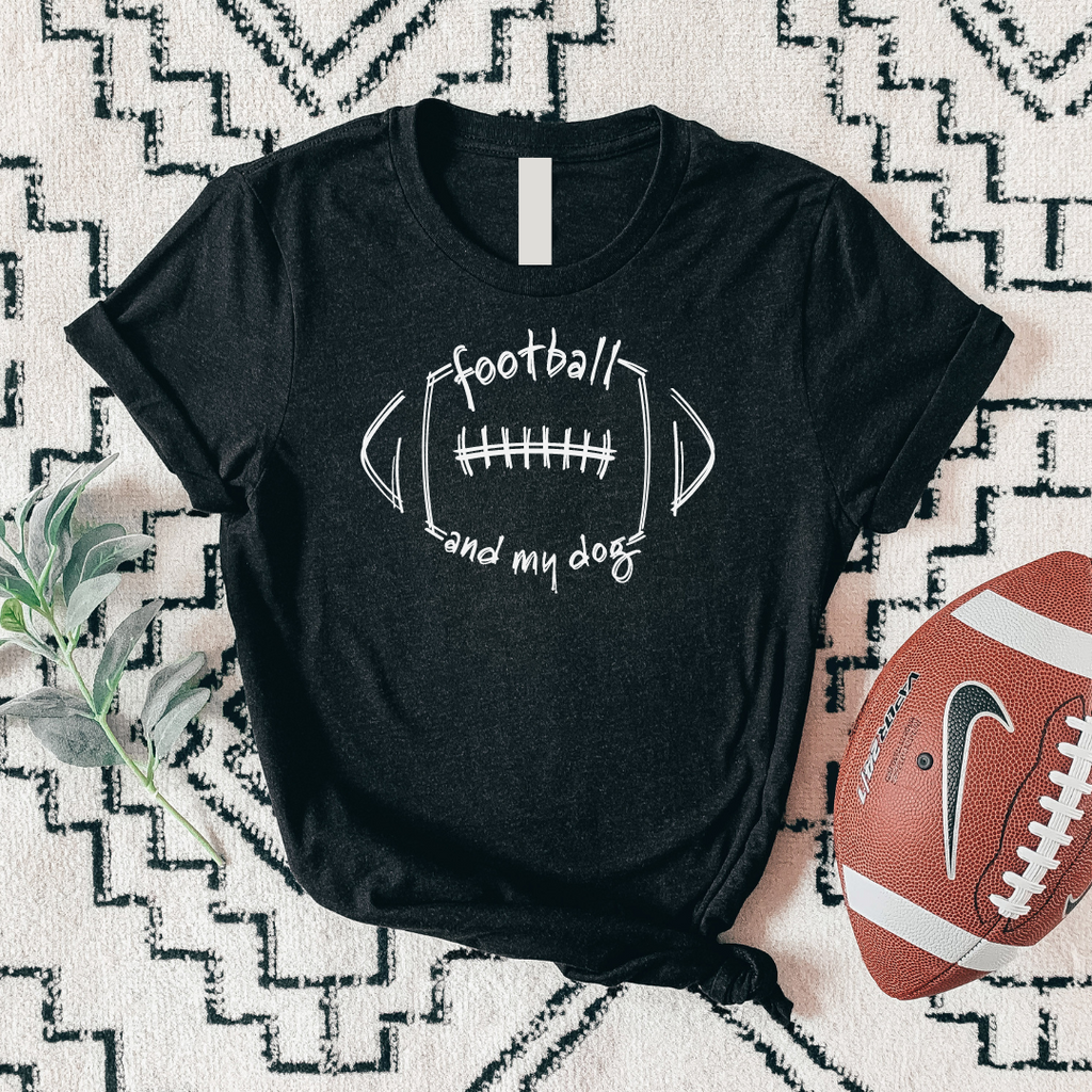 Black t-shirt with 'football and my dog' text on a patterned surface with a football beside it.
