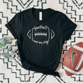 Black t-shirt with 'football and my dog' text on a patterned surface with a football beside it.