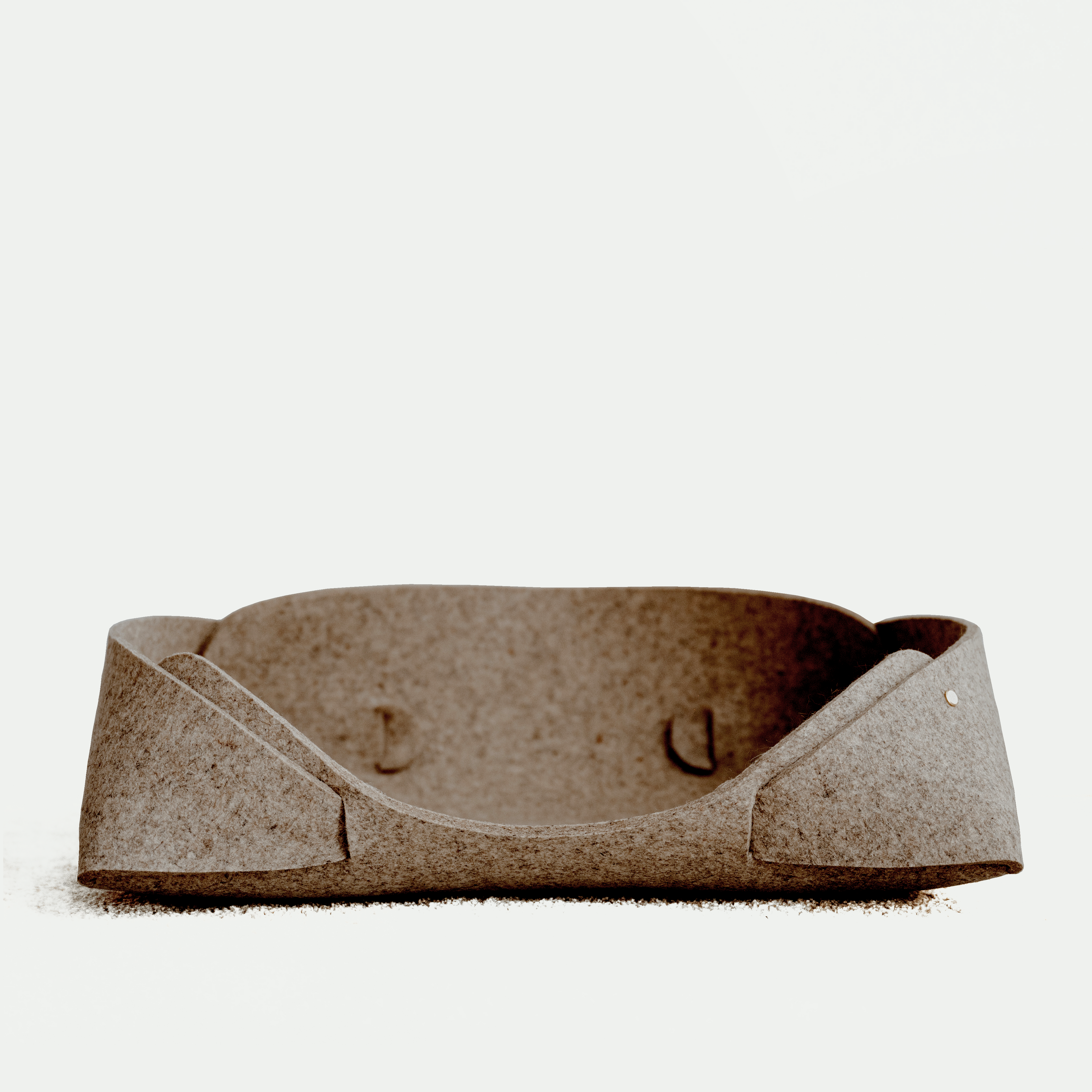 Brown felt pet bed on a white background