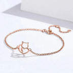 Rose gold bracelet with cat design on a white background