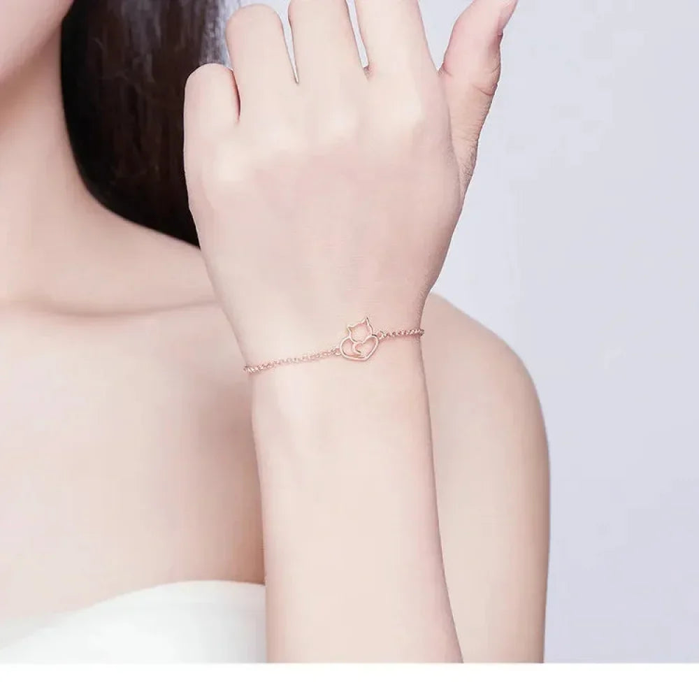 Rose gold bracelet on a person's wrist with a plain background