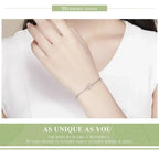 Person wearing a delicate bracelet on a plain background with text about the jewelry.
