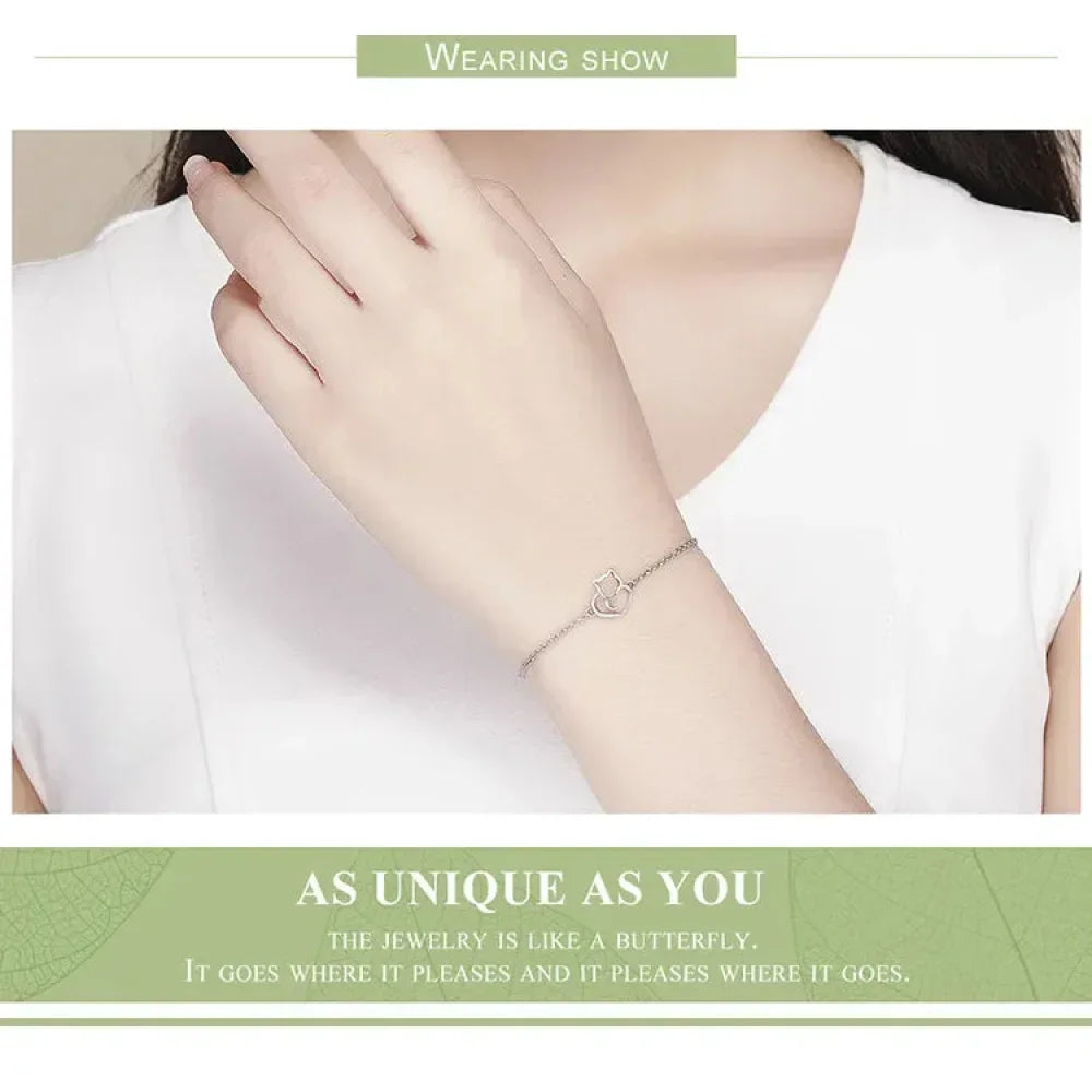 Person wearing a delicate bracelet on a plain background with text about the jewelry.