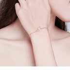 Rose gold bracelet on a person's wrist with a soft background