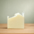 Bar of soap on a wooden surface with a neutral background