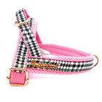 Dog harness with pink and black houndstooth pattern on a white background