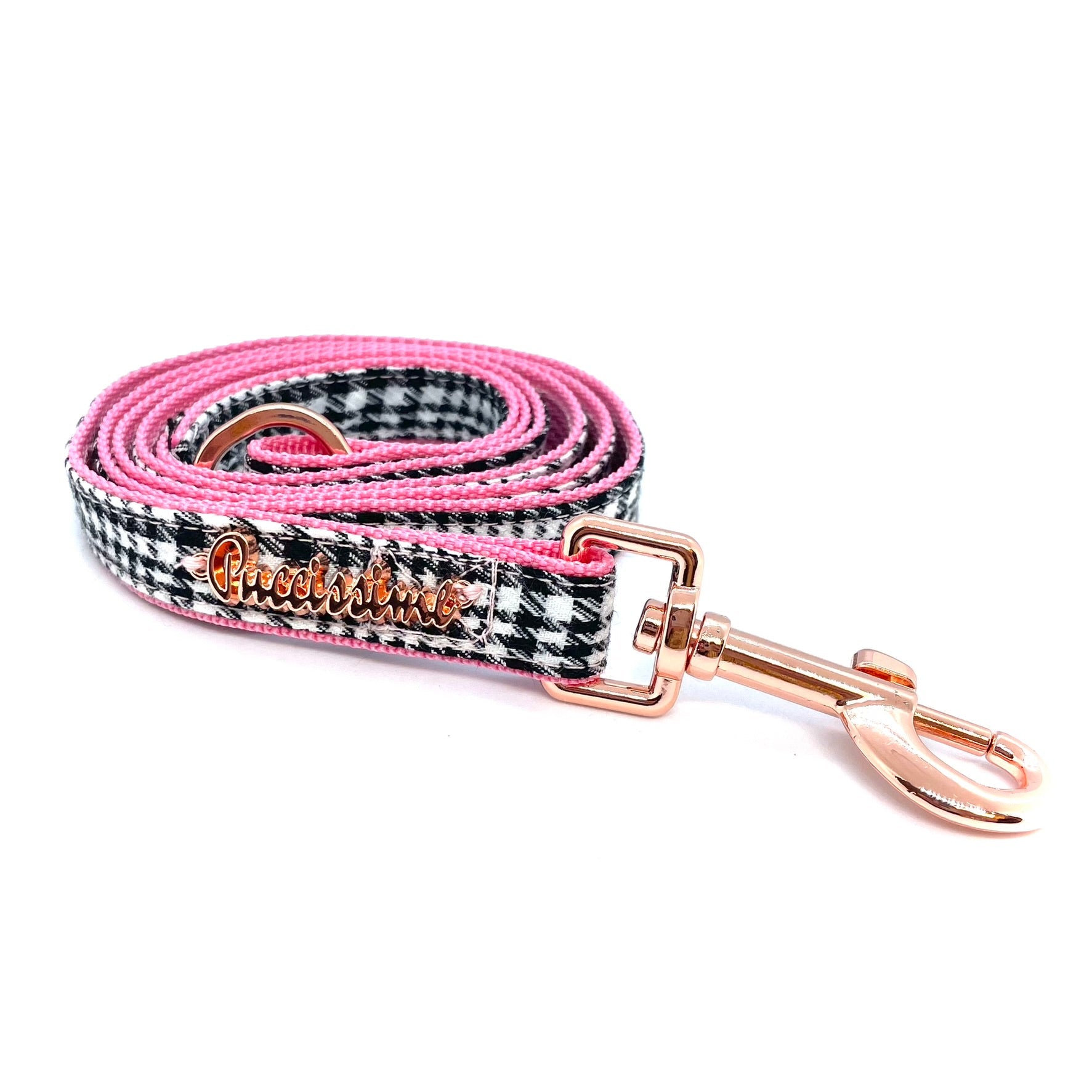 Dog leash with pink and black checkered pattern and rose gold hardware on a white background