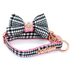 Dog collar with houndstooth pattern, pink accents, and gold hardware on a white background