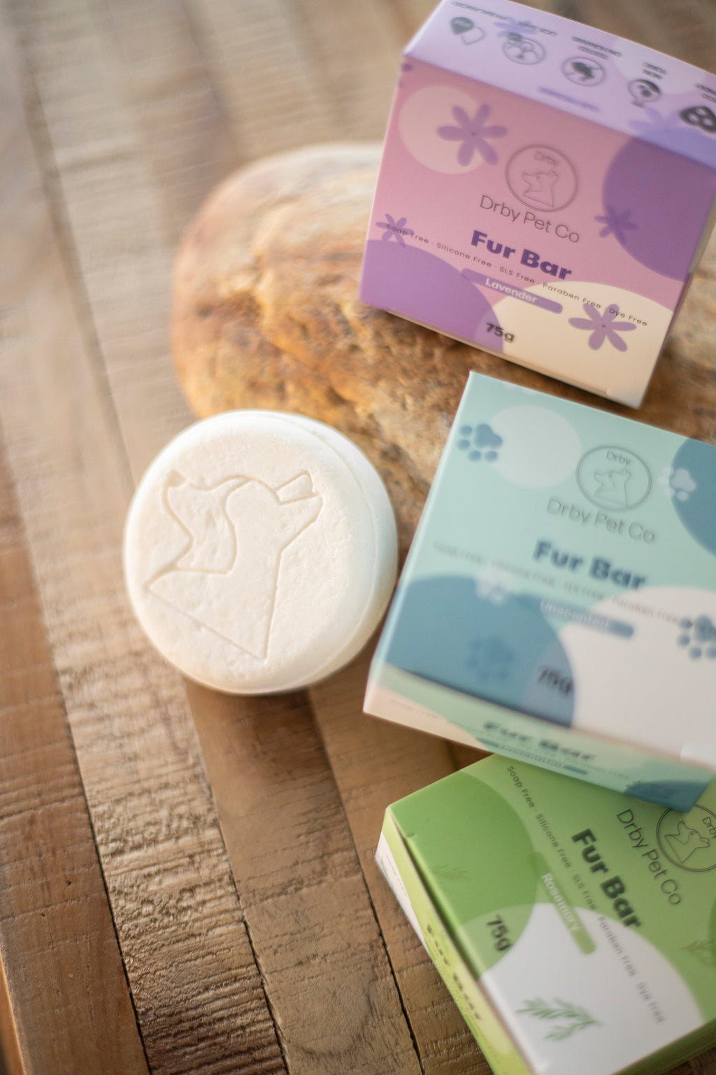 Pet grooming products including a Fur Bar and packaging on a wooden surface