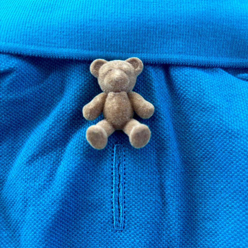 Small teddy bear on a blue textured surface