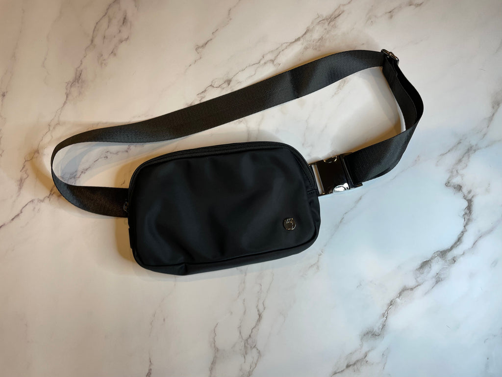 Black Dog walking waist bag on a marble surface