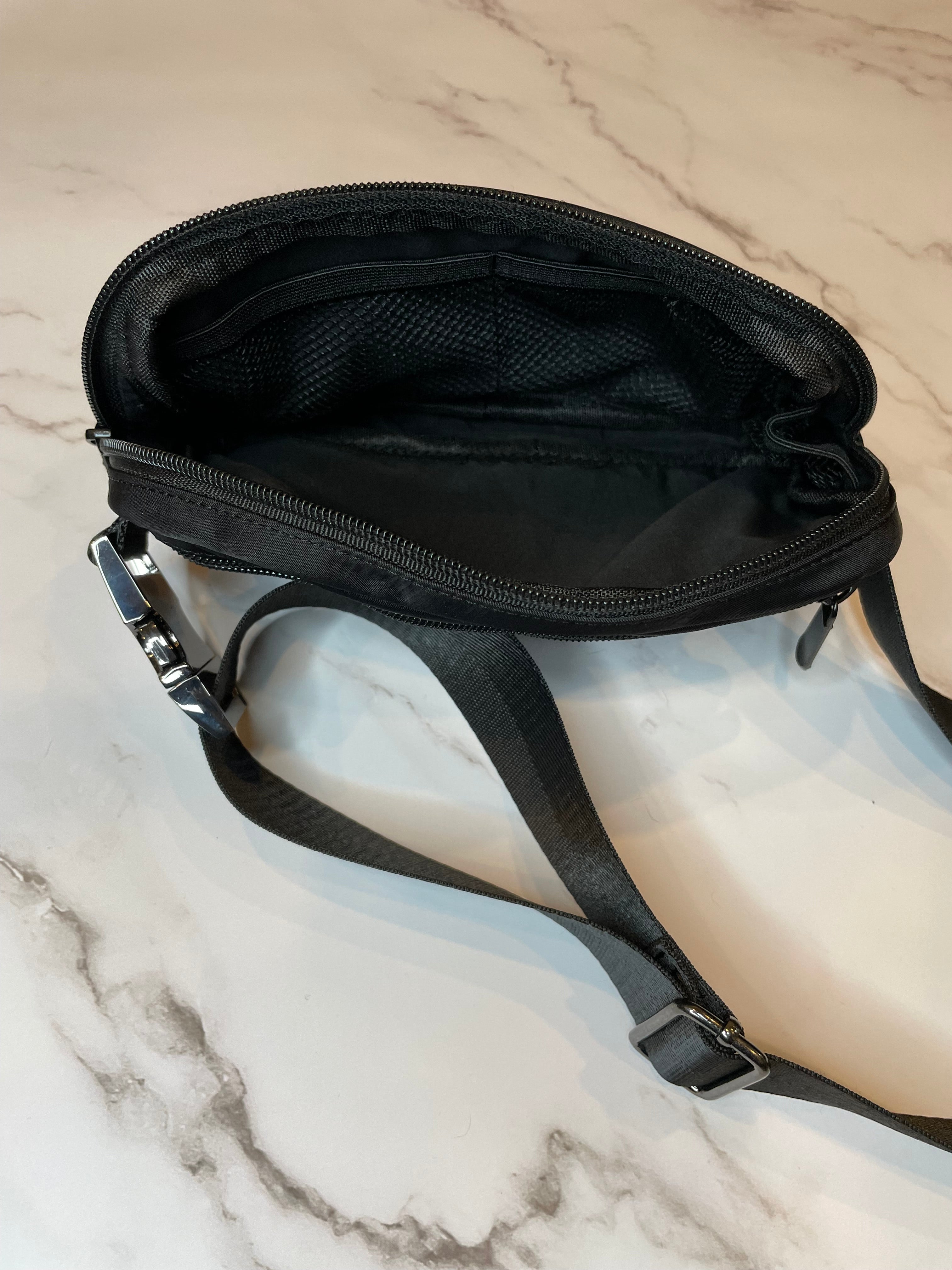 Black crossbody bag on a marble surface