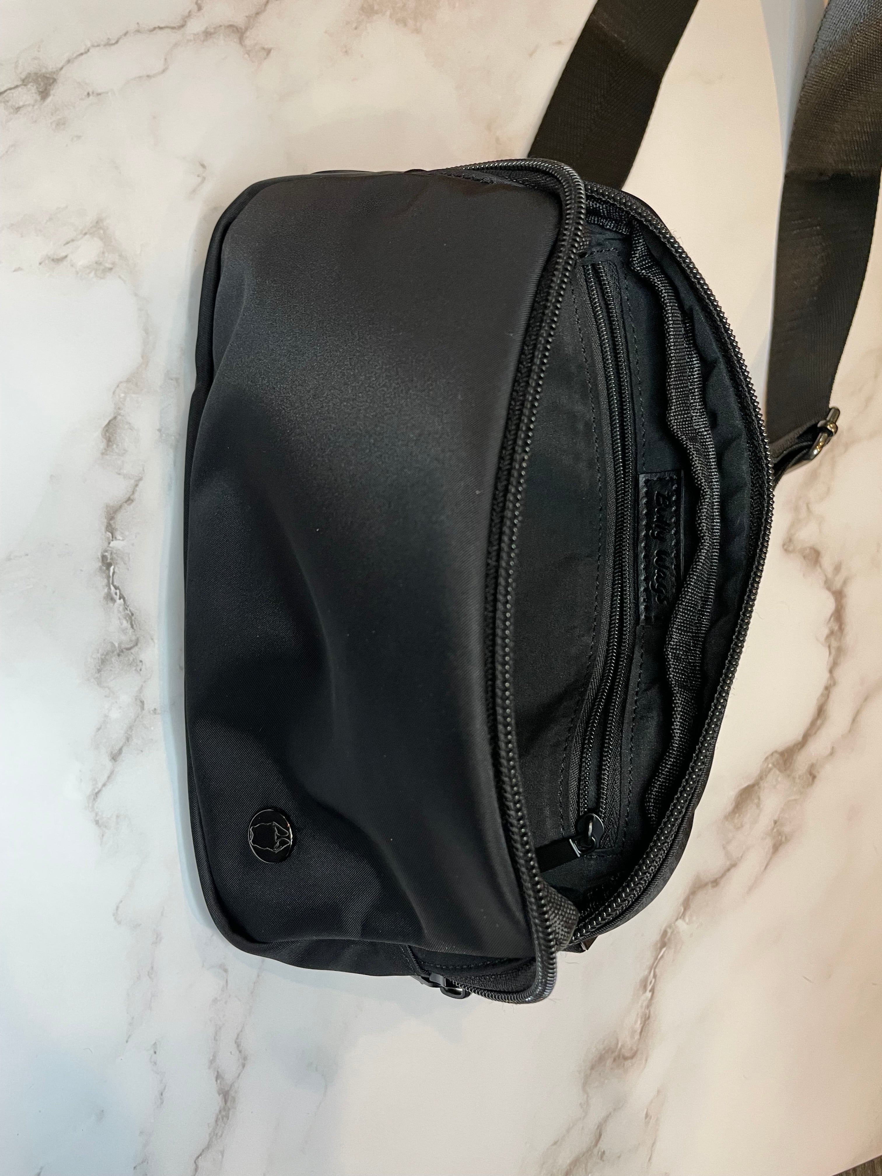 Black dog walk waist bag on a marble surface