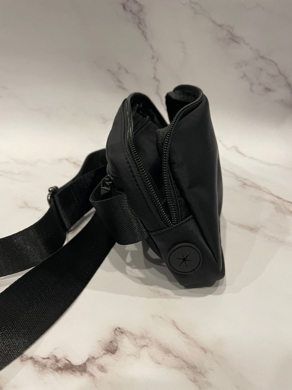 Black dog walk waist bag on a marble surface