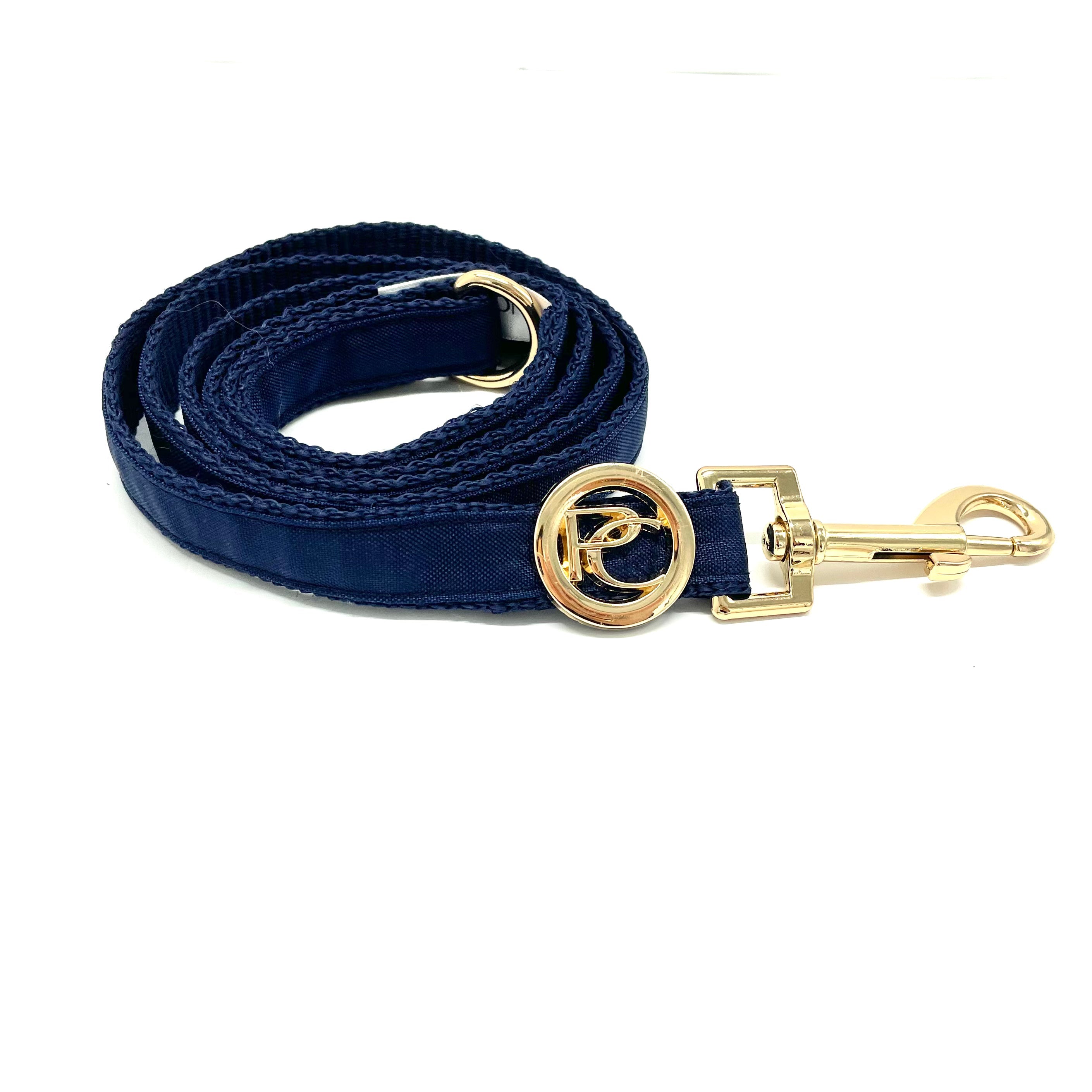 Navy blue dog leash with gold clasp on a white background